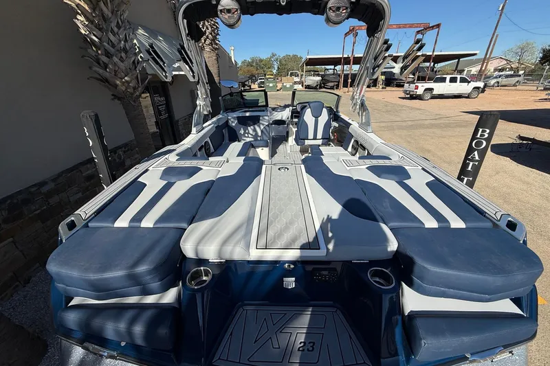 Slide: The Image of 2023 MasterCraft XT23 boat with sleek blue and gray interior design. - 7