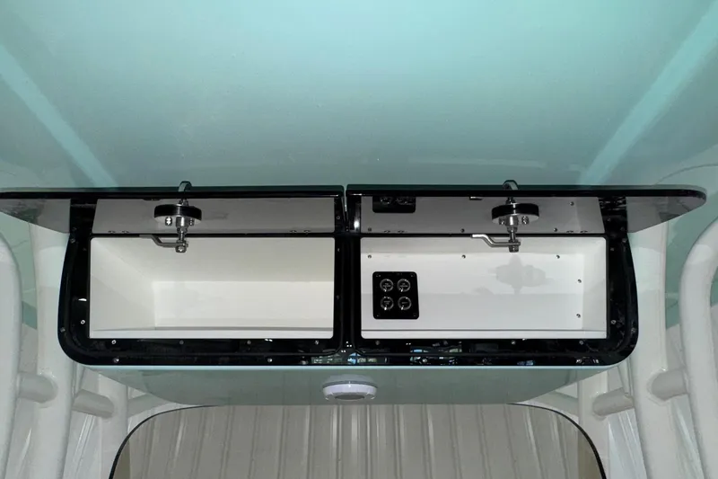 Slide: The Image of 2025 Key West 263 FS boat storage compartments with secure latches and control panel. - 15