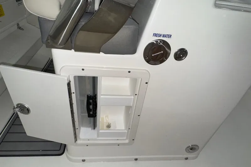 Slide: The Image of 2025 Key West 263 FS boat interior with open storage compartment and fresh water access. - 18