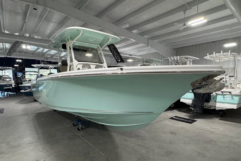 Slide: The Image of 2025 Key West 263 FS boat in showroom, mint green hull, sleek design. - 2