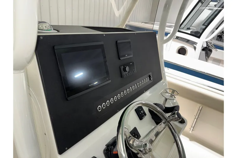 Slide: The Image of 2025 Key West 263 FS boat dashboard with steering wheel and electronic controls. - 27