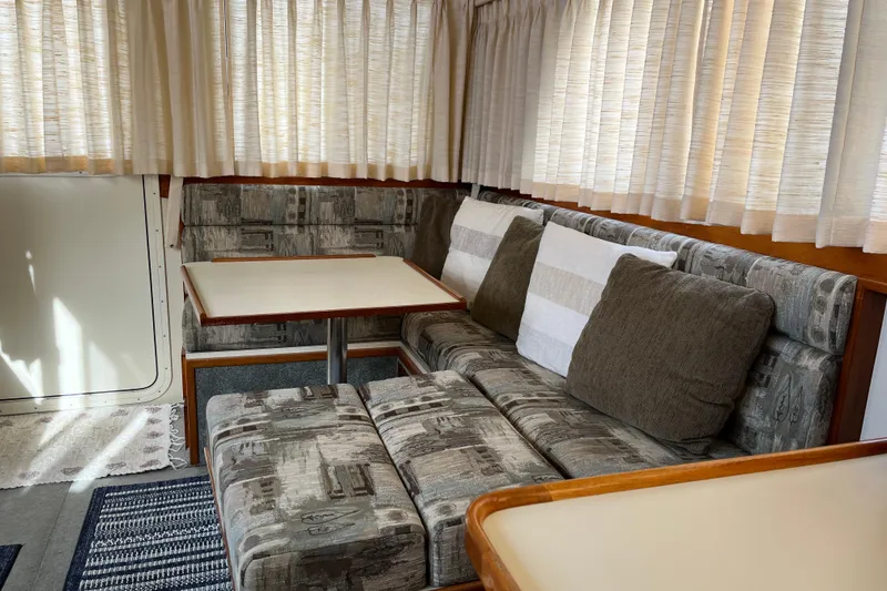 Slide: The Image of 2005 Camano Trawler interior with cozy seating, table, and curtains. - 10