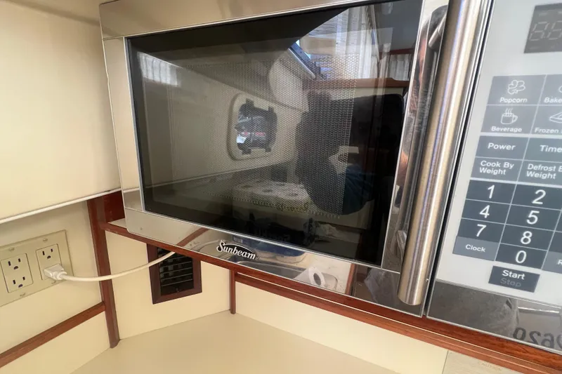 Slide: The Image of Sunbeam microwave in 2005 Camano Trawler kitchen, featuring control panel and power outlet. - 18