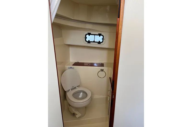 Slide: The Image of 2005 Camano Trawler bathroom with toilet and porthole window. - 21
