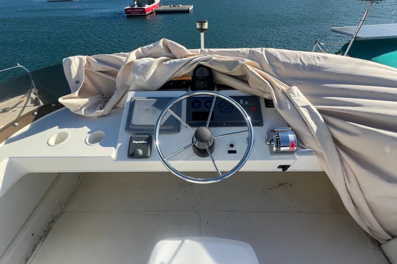 Slide: The Image of 2005 Camano Trawler helm with covered dashboard, steering wheel, and throttle controls. - 40