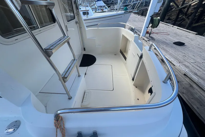 Slide: The Image of 2005 Camano Trawler boat deck with stainless steel ladder and dock view. - 6