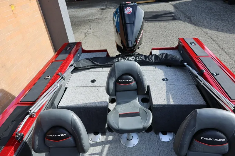 Slide: The Image of 2022 Tracker Targa V-19 WT boat interior with seating and motor, red and gray design. - 10
