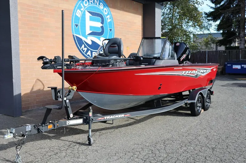 Slide: The Image of 2022 Tracker Targa V-19 WT boat in vibrant red, parked outside Bjornson Marine. - 19