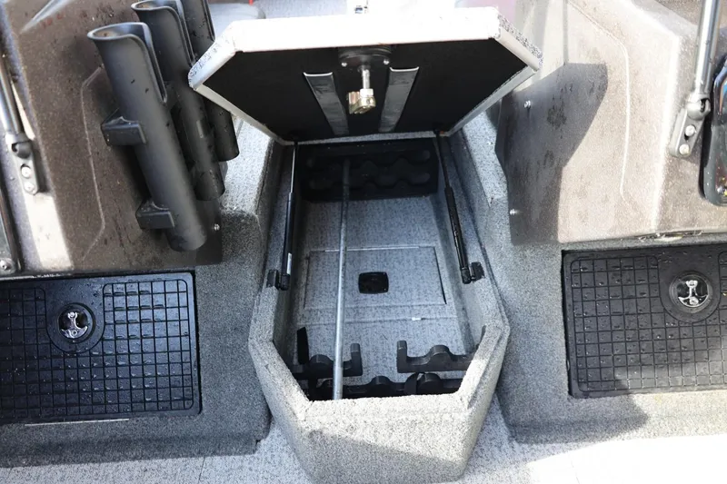Slide: The Image of 2022 Tracker Targa V-19 WT boat storage compartment with rod holders and carpeted interior. - 6