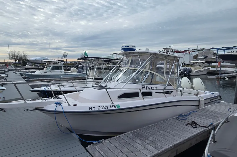 The Image of 2003 Grady-White Voyager 258 boat docked at marina under cloudy sky. - 0