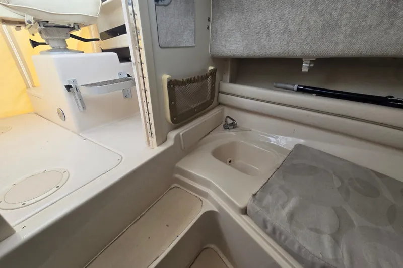 Slide: The Image of 2003 Grady-White Voyager 258 interior with seating, storage, and beige upholstery. - 12