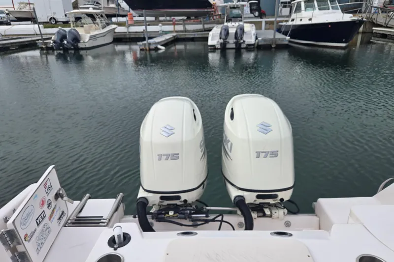 Slide: The Image of Twin Suzuki 175 outboard engines on a 2003 Grady-White Voyager 258 boat at a marina. - 13