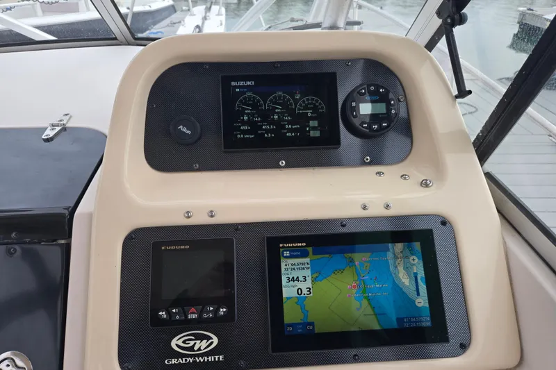 Slide: The Image of Dashboard of a 2003 Grady-White Voyager 258 boat with navigation and control displays. - 2