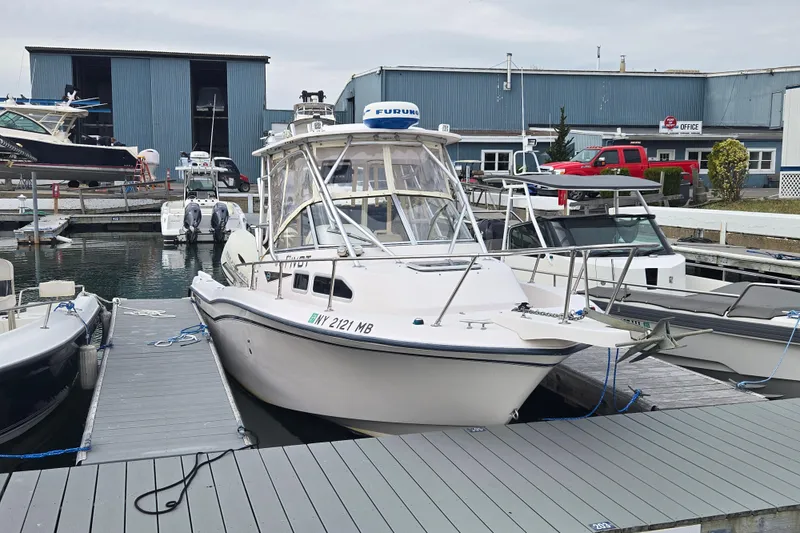 Slide: The Image of 2003 Grady-White Voyager 258 boat docked at a marina with other vessels. - 3
