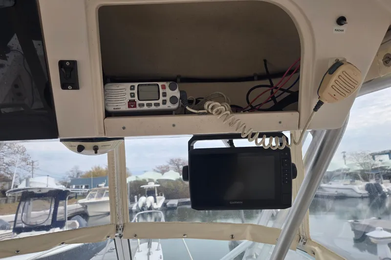 Slide: The Image of 2003 Grady-White Voyager 258 boat dashboard with radio and Garmin display. - 6
