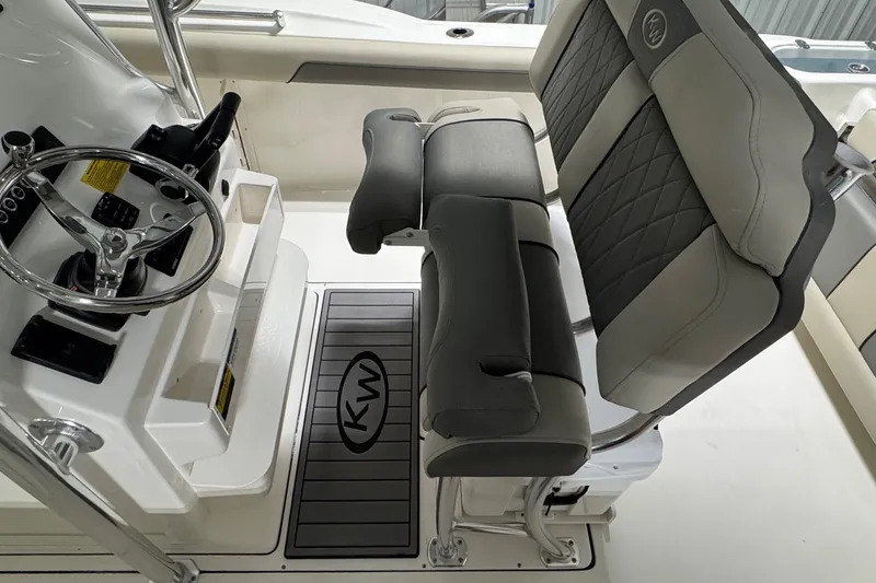 Slide: The Image of 2026 Key West 244 Center Console boat interior with steering wheel and cushioned seating. - 12