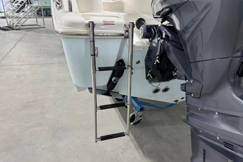 Slide: The Image of 2026 Key West 244 Center Console boat with ladder and outboard motor in a showroom. - 4