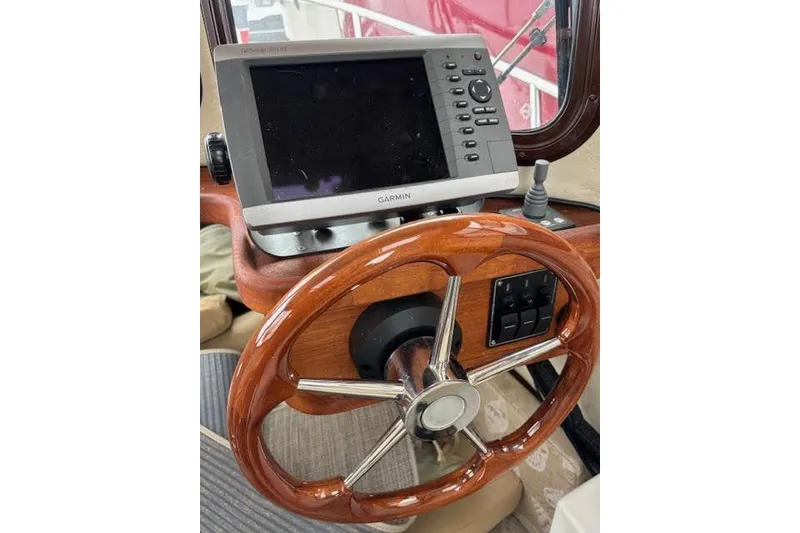 Slide: The Image of 2009 Ranger Tugs R21-EC helm with Garmin GPS and wooden steering wheel. - 21