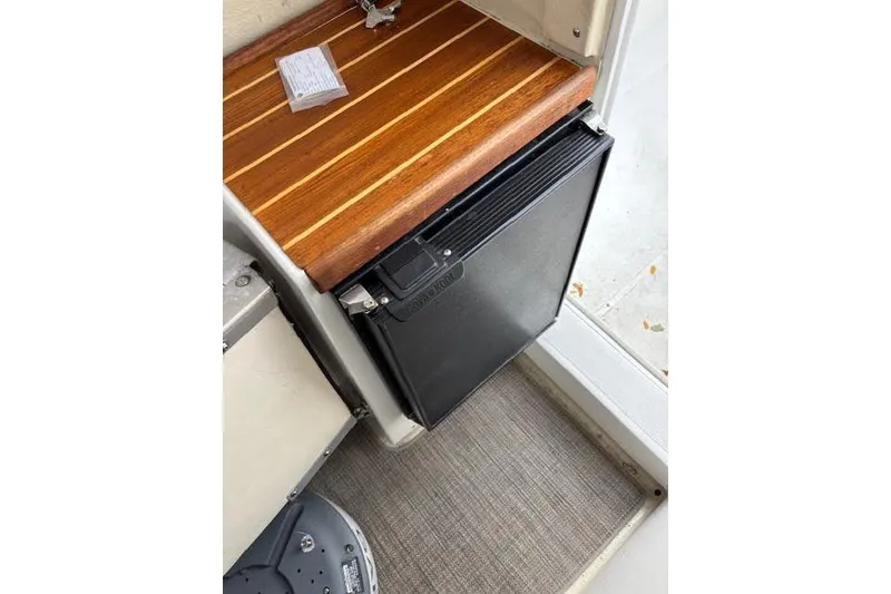 Slide: The Image of 2009 Ranger Tugs R21-EC interior with compact fridge and wooden countertop. - 27