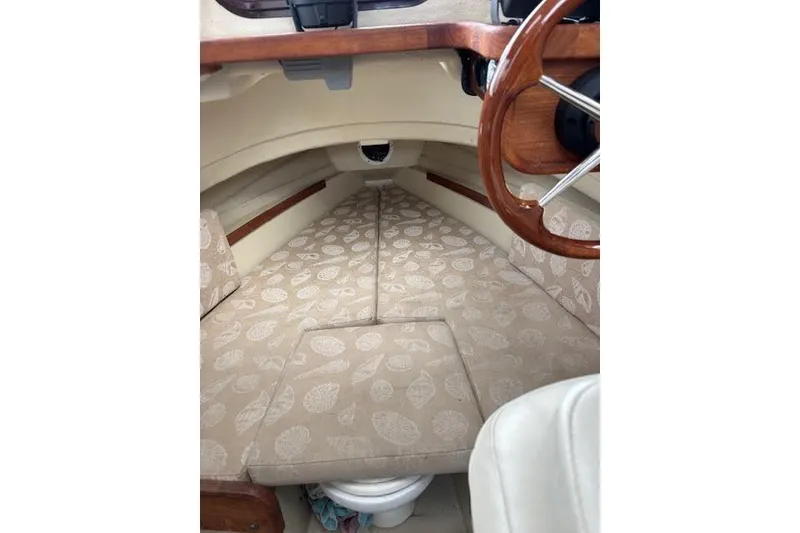 Slide: The Image of 2009 Ranger Tugs R21-EC cabin interior with patterned cushions and wooden steering wheel. - 31