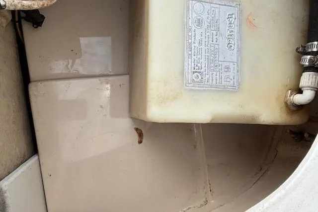 Slide: The Image of 2009 Ranger Tugs R21-EC engine compartment with a labeled plastic tank and connected hoses. - 35