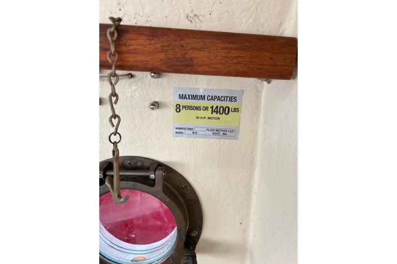 Slide: The Image of 2009 Ranger Tugs R21-EC capacity sign, 8 persons or 1400 lbs, near porthole. - 39