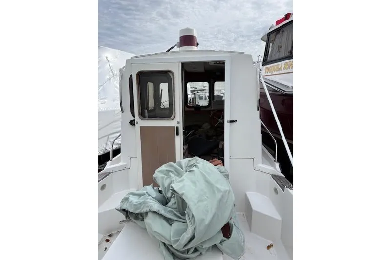 Slide: The Image of 2009 Ranger Tugs R21-EC boat with open cabin door and tarp on deck. - 7