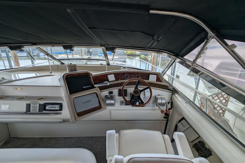 Slide: The Image of 1994 Sea Ray 500 Sundancer helm with Garmin navigation, steering wheel, and control panel. - 13