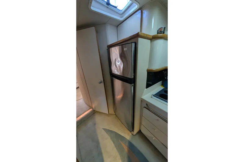 Slide: The Image of 1994 Sea Ray 500 Sundancer yacht interior with stainless steel fridge and compact kitchen. - 29