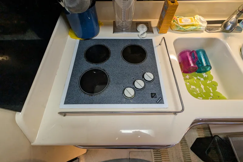 Slide: The Image of 1994 Sea Ray 500 Sundancer kitchen with stovetop and sink area. - 30