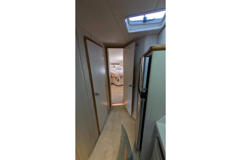 Slide: The Image of Interior hallway of 1994 Sea Ray 500 Sundancer yacht, featuring doors and skylight. - 31