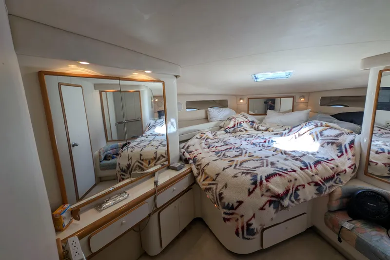 Slide: The Image of Luxurious 1994 Sea Ray 500 Sundancer cabin interior with cozy bed and mirrored storage. - 32