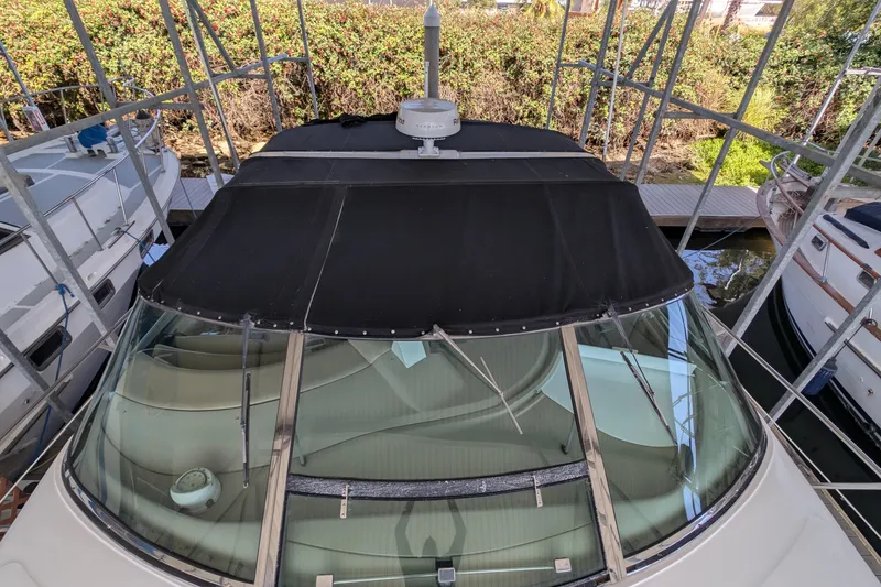 Slide: The Image of 1994 Sea Ray 500 Sundancer yacht with black canopy, docked in a marina. - 4