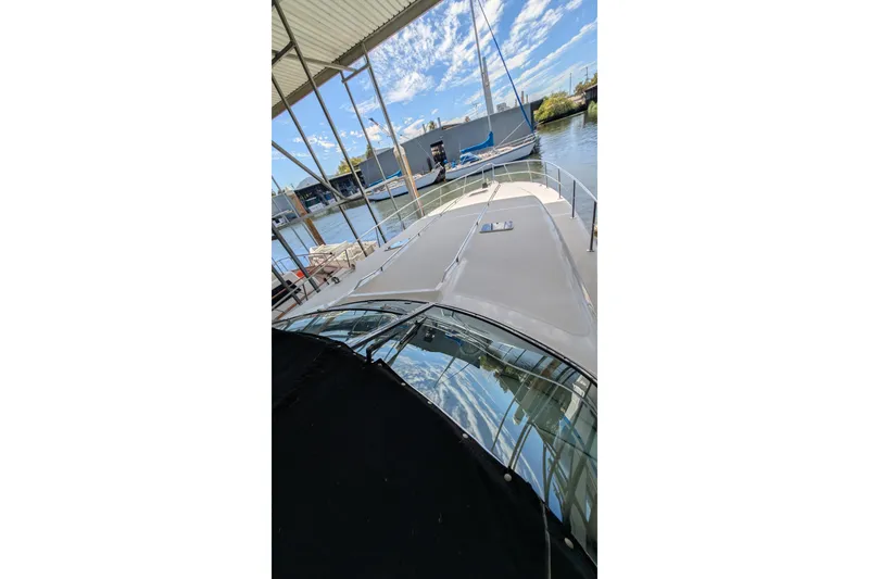 Slide: The Image of 1994 Sea Ray 500 Sundancer yacht docked under a canopy on a sunny day. - 8