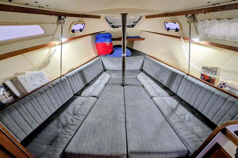Slide: The Image of Interior of a 1990 Catalina Capri 26 sailboat with cushioned seating and storage. - 16