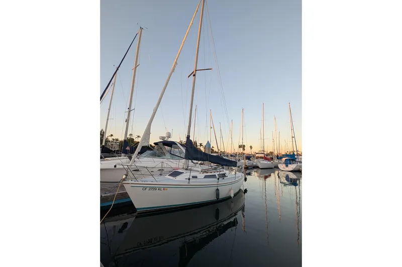 Slide: The Image of 1990 Catalina Capri 26 sailboat docked in a marina at sunset. - 24