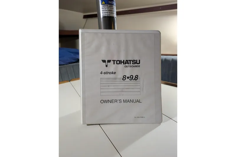 Slide: The Image of Tohatsu outboard owner's manual on a Catalina Capri 26 sailboat table. - 39
