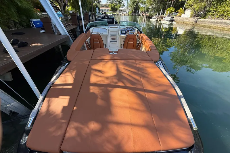 Slide: The Image of 2018 Chris-Craft Capri 27 boat with tan upholstery docked on a serene canal. - 11