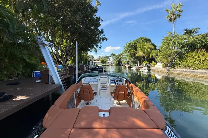 Slide: The Image of 2018 Chris-Craft Capri 27 boat docked on a scenic, tree-lined waterway. - 12