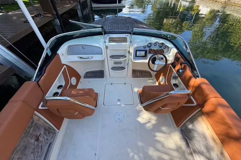 Slide: The Image of 2018 Chris-Craft Capri 27 boat interior with tan seating and modern dashboard. - 15
