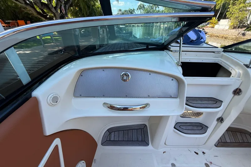 Slide: The Image of 2018 Chris-Craft Capri 27 interior with sleek dashboard and storage compartments. - 18