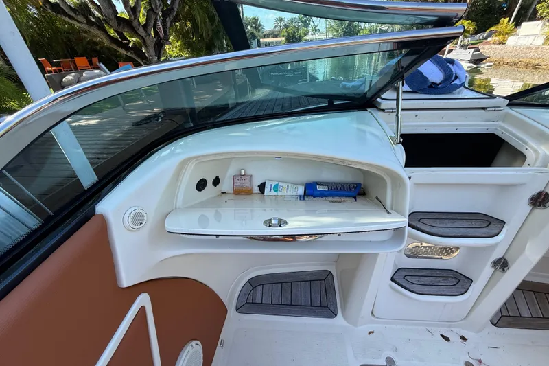 Slide: The Image of 2018 Chris-Craft Capri 27 interior with storage compartment and open deck view. - 19