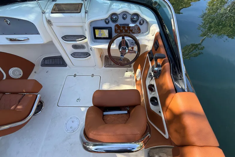 Slide: The Image of 2018 Chris-Craft Capri 27 cockpit with brown leather seats and modern dashboard controls. - 20