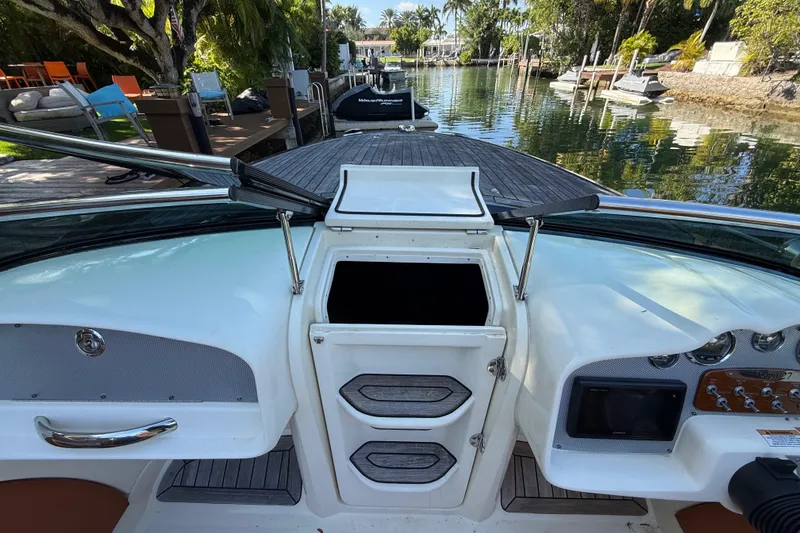 Slide: The Image of 2018 Chris-Craft Capri 27 boat interior with dashboard and waterway view. - 30