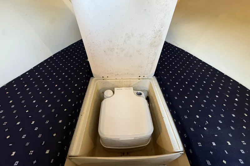 Slide: The Image of 2018 Chris-Craft Capri 27 interior storage compartment with portable toilet. - 34