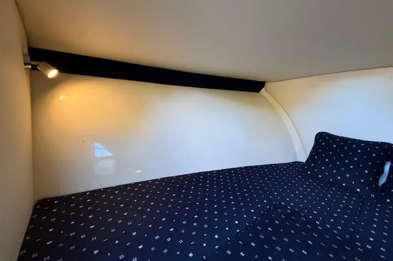 Slide: The Image of 2018 Chris-Craft Capri 27 cabin interior with cozy bed and reading light. - 37