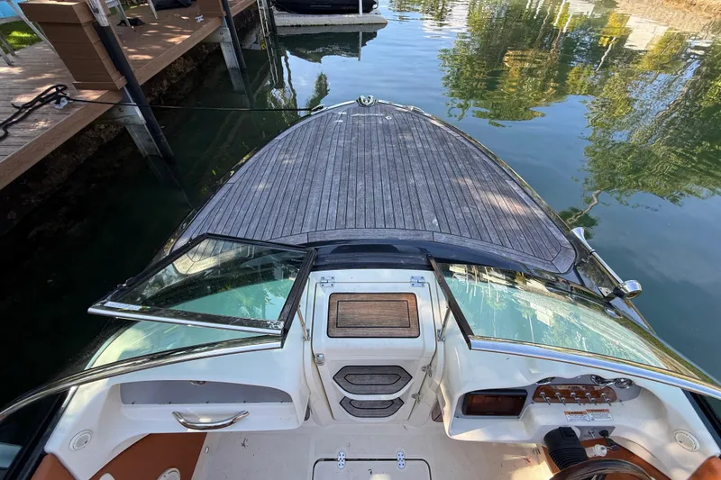 Slide: The Image of 2018 Chris-Craft Capri 27 boat docked, featuring sleek design and wooden deck. - 42