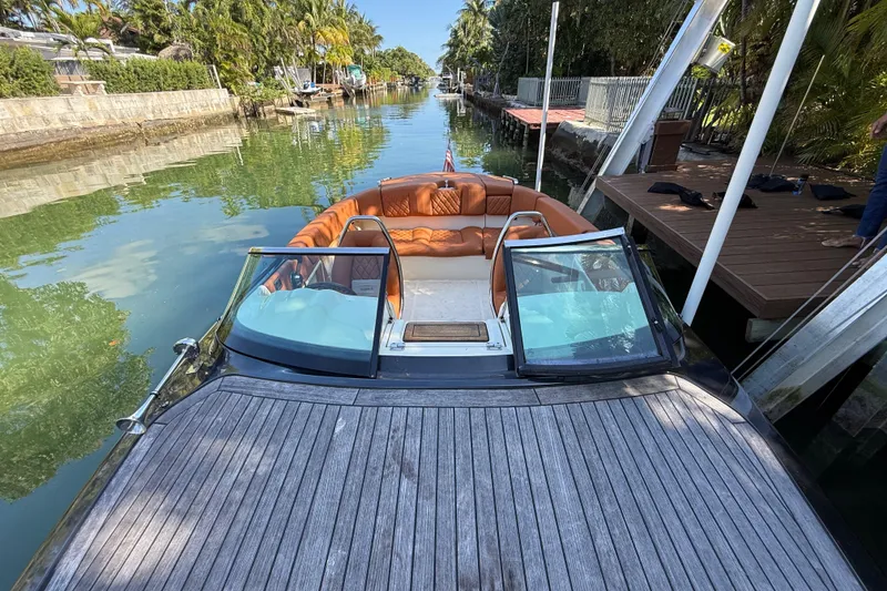 Slide: The Image of 2018 Chris-Craft Capri 27 boat docked on a serene canal with lush greenery. - 49