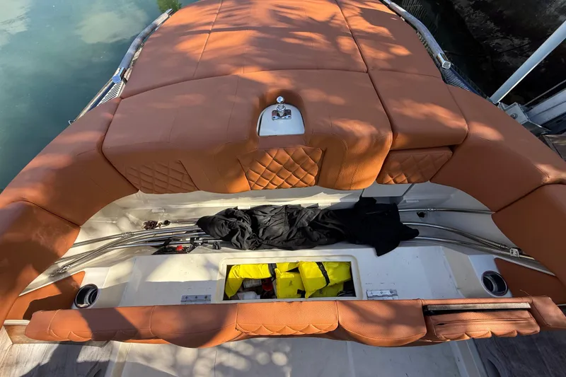 Slide: The Image of 2018 Chris-Craft Capri 27 boat with tan leather seating and storage compartments. - 58