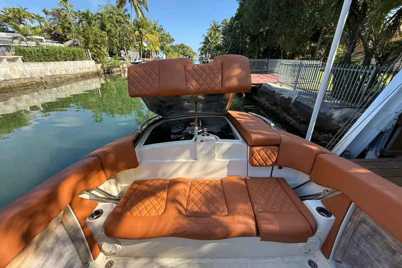 Slide: The Image of 2018 Chris-Craft Capri 27 boat interior with tan leather seating and open engine compartment. - 61